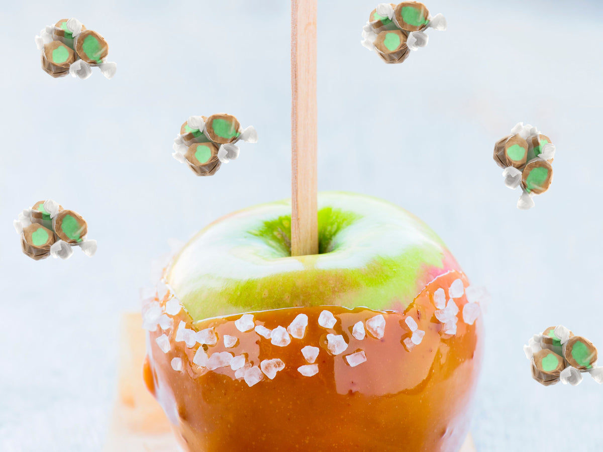 Up close shot of one caramel apple with sea salt, in the background floating taffy