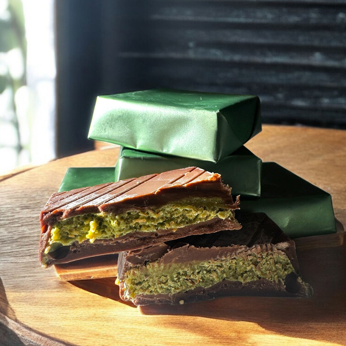 Milk and dark chocolate pistachio bars cut open to show green filling