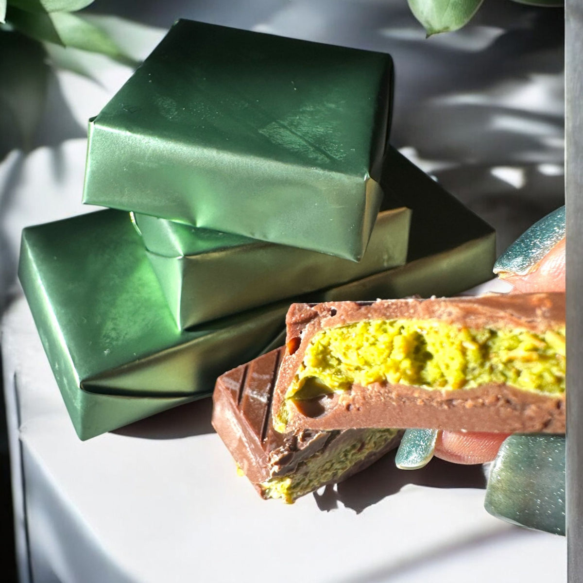 tacked pistachio chocolate bars wrapped in metallic green with pistachio filling inside