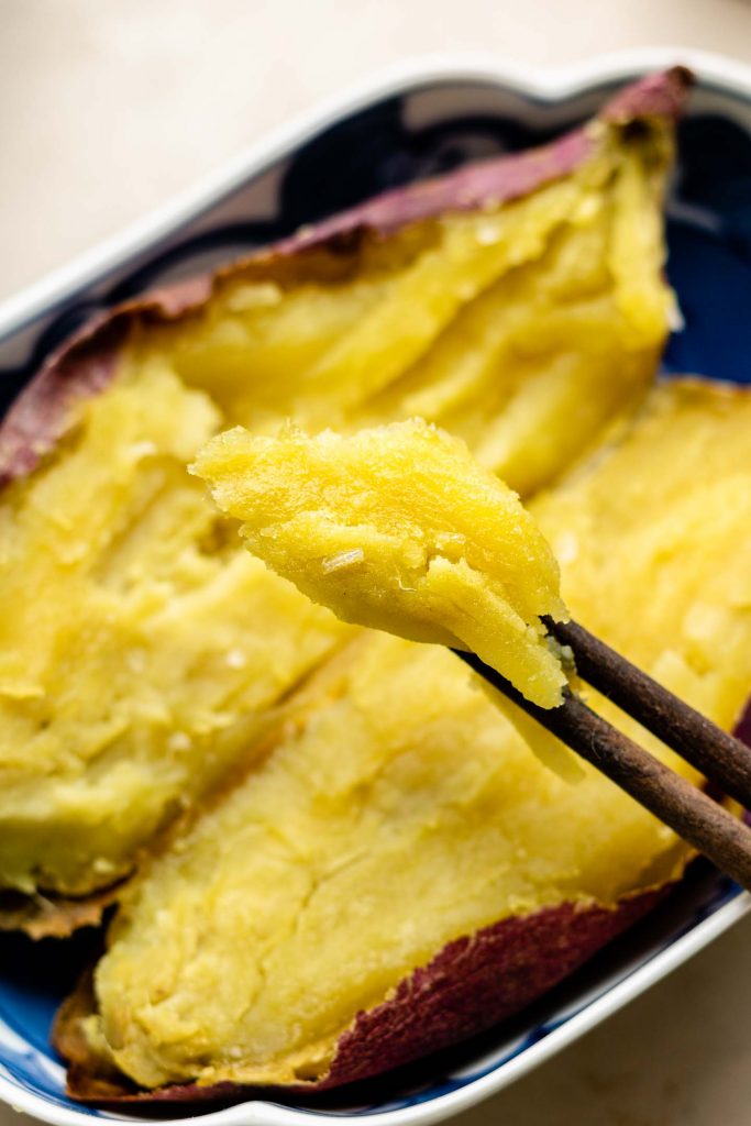  "Baked Japanese sweet potatoes, also known as Yaki Imo, with a crispy and caramelized red-purple skin, and a creamy, sweet, and fluffy texture. A popular and nutritious snack, perfect for fall and winter with chopsticks